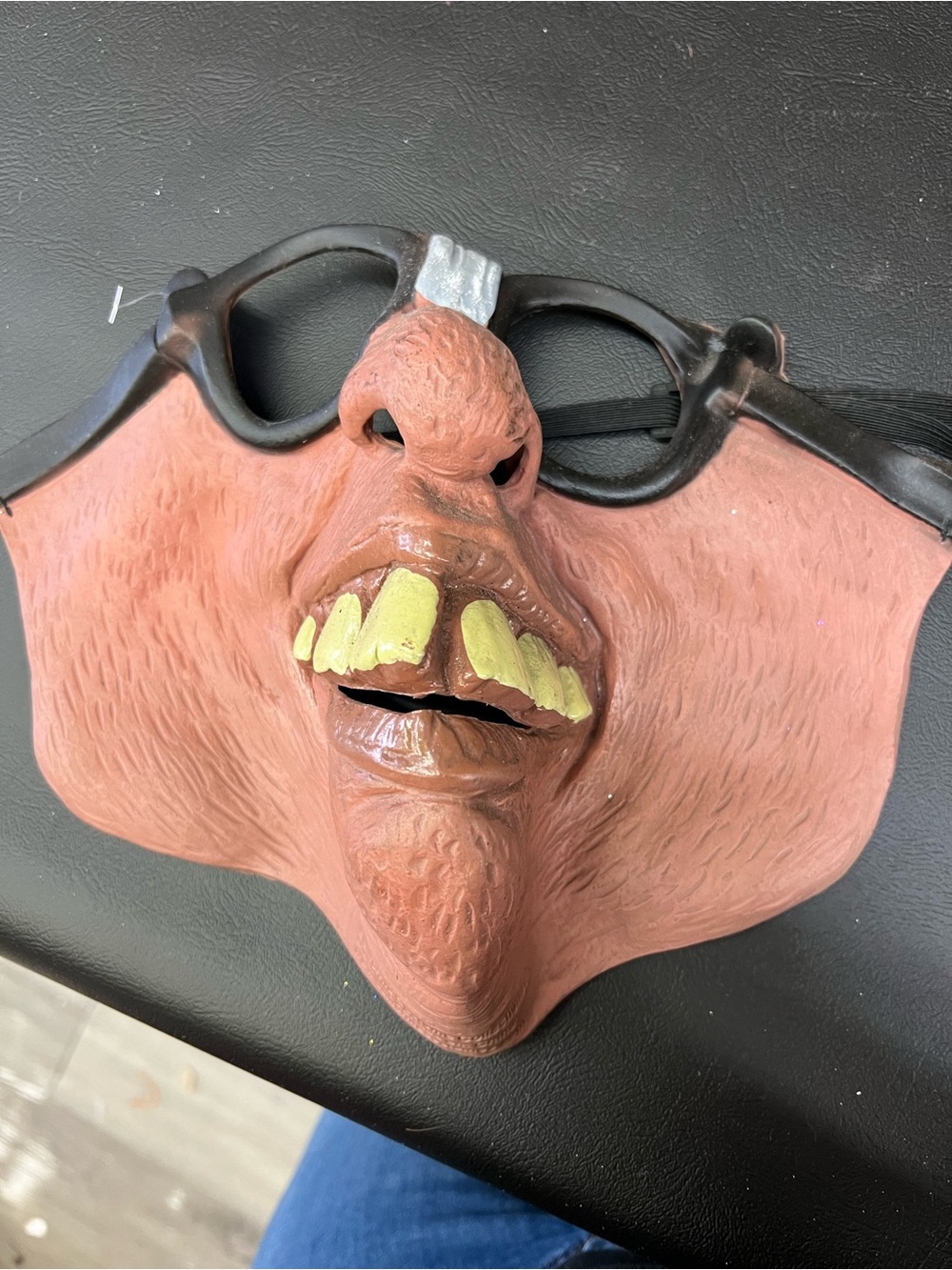 Gothic horror mask with yellow teeth and black glasses